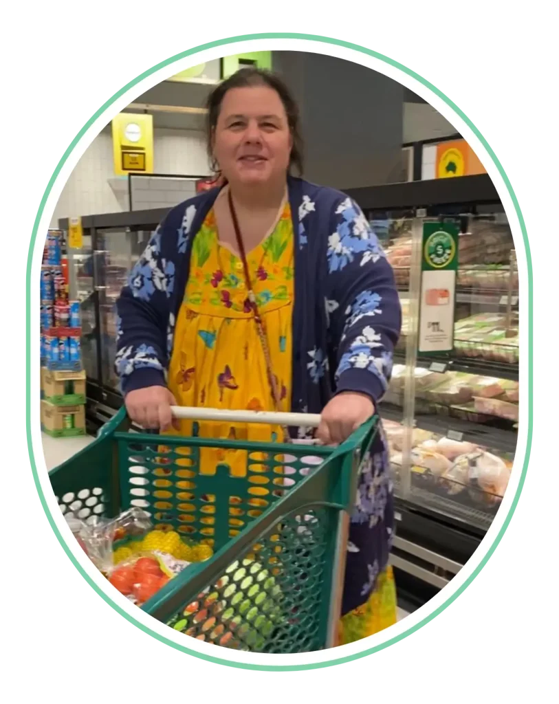 Smiling woman pushing a shopping trolley in a supermarket, framed in a green oval